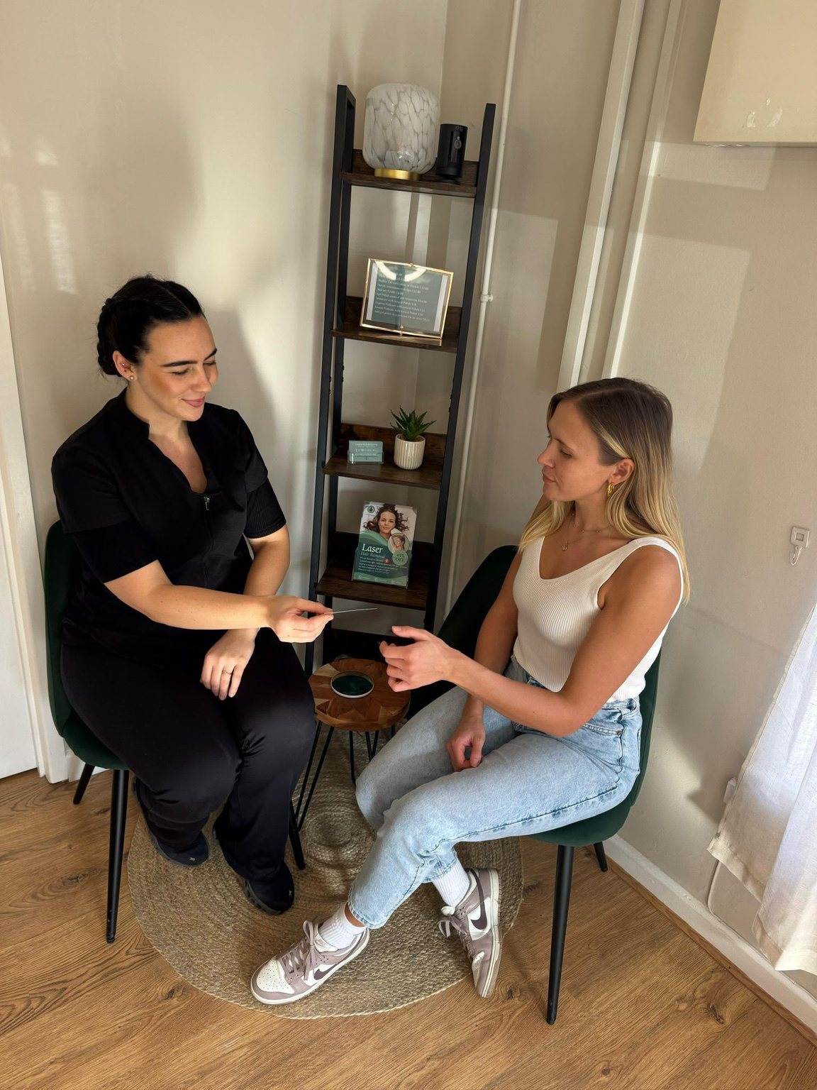 Leya Lopez seated with a client in the treatment room, talking through a treatment plan